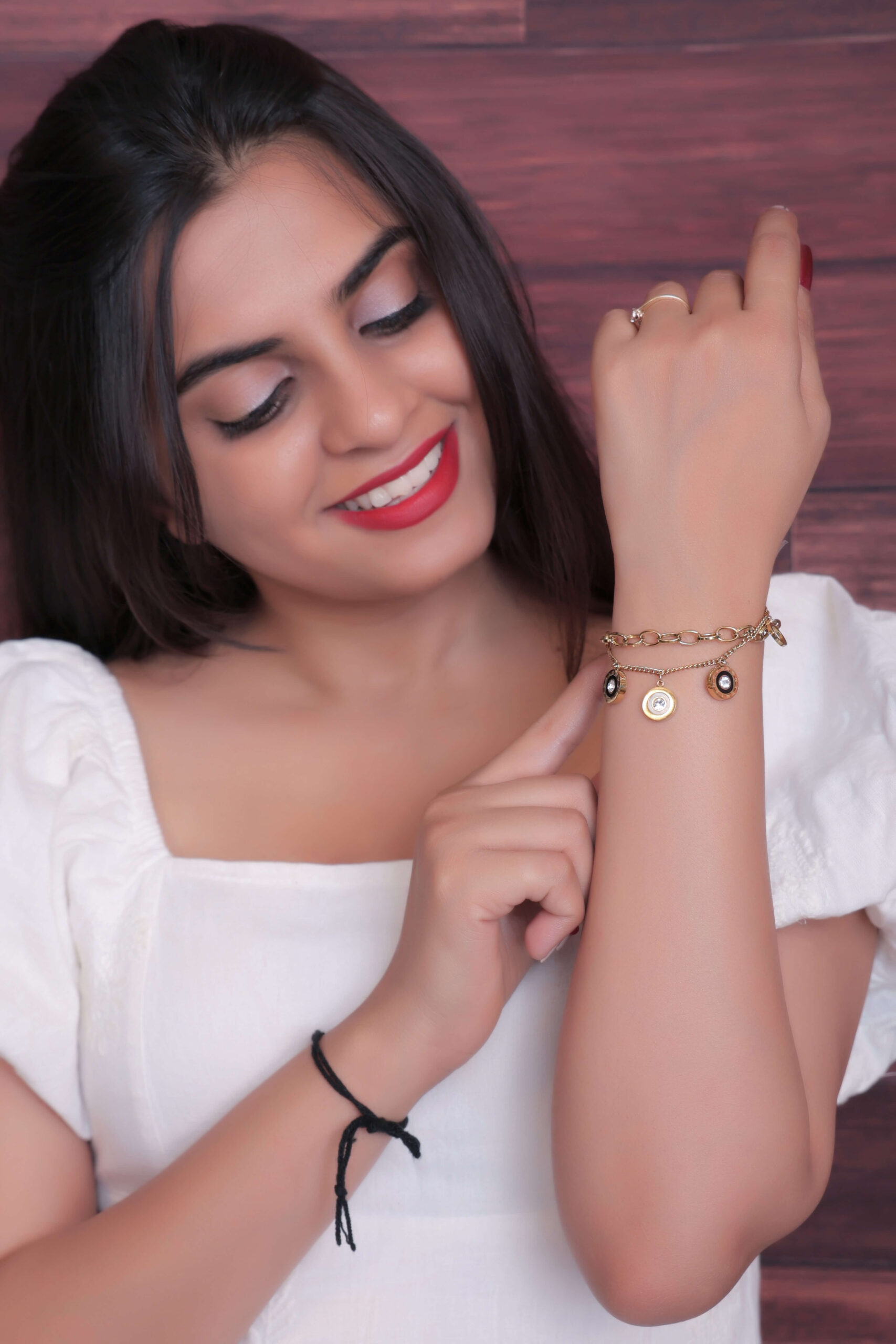 Woman showcasing a Gold-Toned Charm Bracelet - Image 2