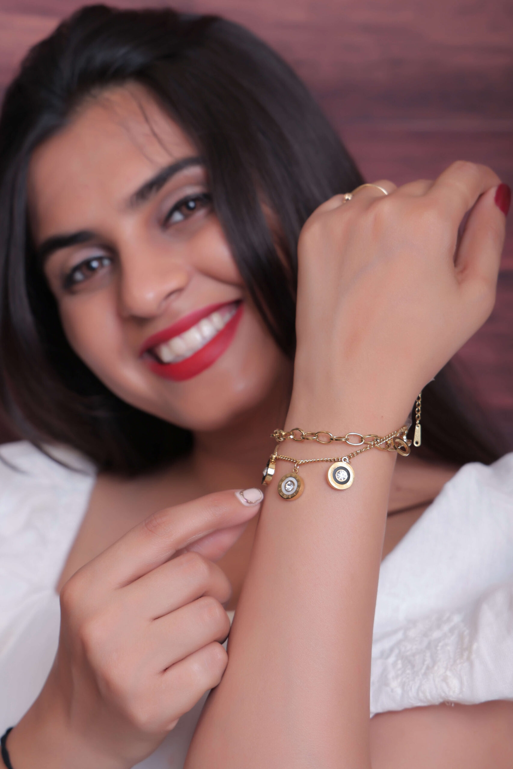 Woman showcasing a Gold-Toned Charm Bracelet