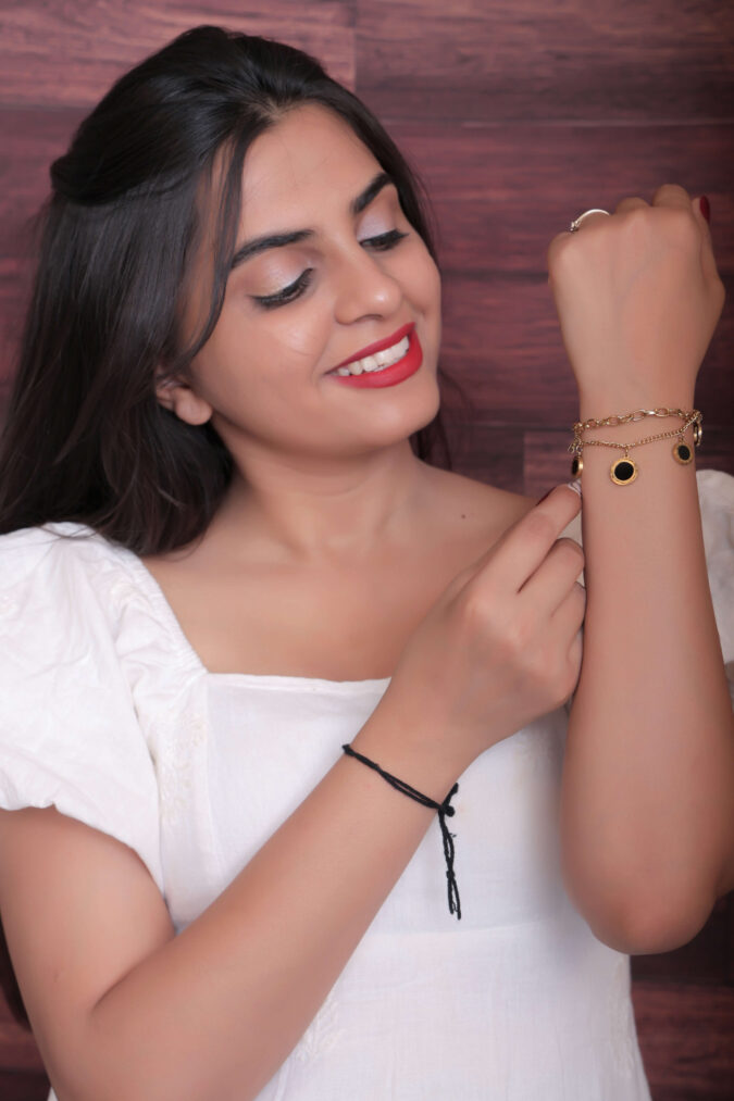 Woman Adjusting a Gold-Toned Charm Bracelet